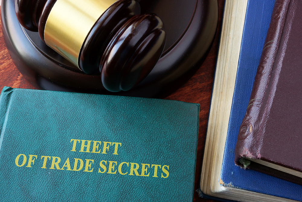 Gavel next to a book saying 'Theft of Trade Secrets'
